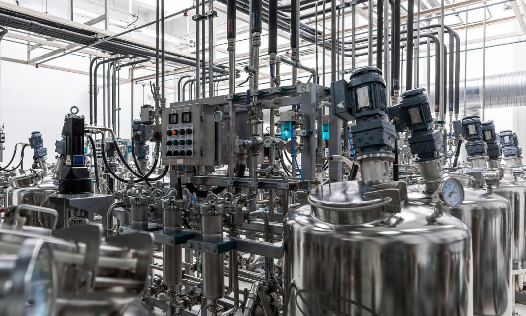 Photo of grey pipes and tanks. Chemistry and medicine production. Pharmaceutical factory. Interior of a high-tech factory, modern production Фармацевтическое оборудование